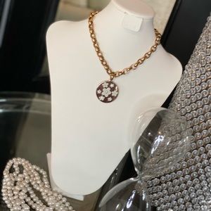 Gold tone necklace with flower white tones charm